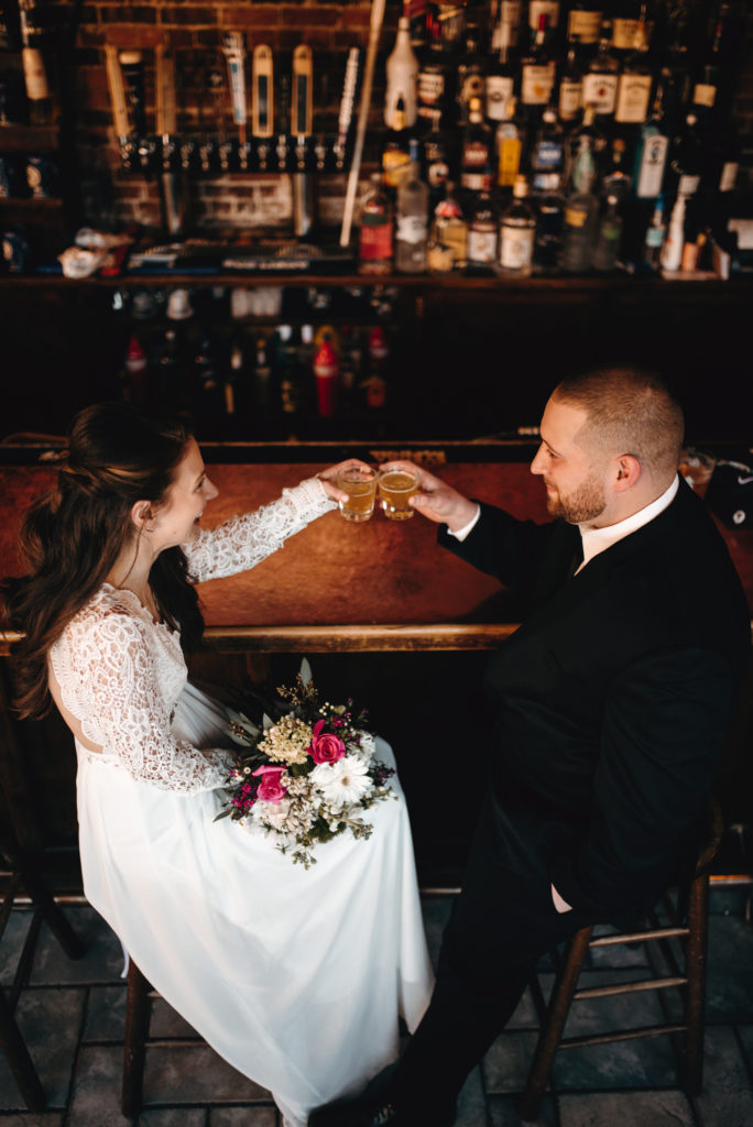 Bride and groom sit on bar stools at copper bar, clinking whiskey glasses to celebrate their Midcoast Maine elopement.
Owls Head, Maine elopement. Midcoast Maine wedding photographer. Maine elopement photographer. Maine adventure photographer.
